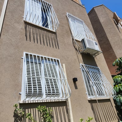 סורגים לבנים על חלונות בניין חום