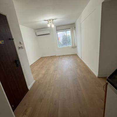 חדר עם רצפת פרקט, קירות לבנים וחלון גדול