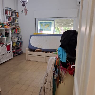 חדר עם מיטה, מדפים וספרים, ללא אלמנטים של ציור.