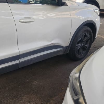 רכב לבן עם שריטות קלות על הדלת הקדמית