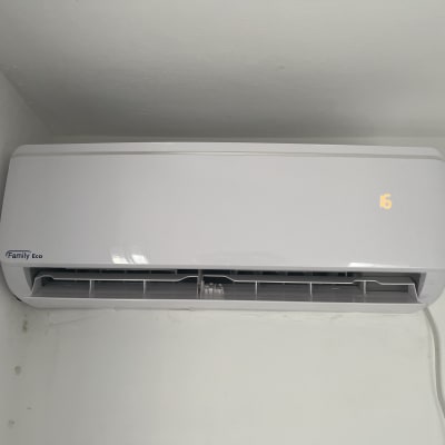 מזגן קיר לבן עם תצוגה דיגיטלית מוארת