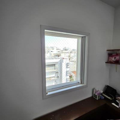 חלון אלומיניום עם רשת מגן על קיר לבן