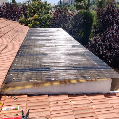 גג רעפים עם יריעת פלסטיק שקופה וכלי עבודה