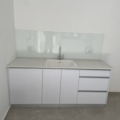 מגן זכוכית שקוף מאחורי הכיור במטבח