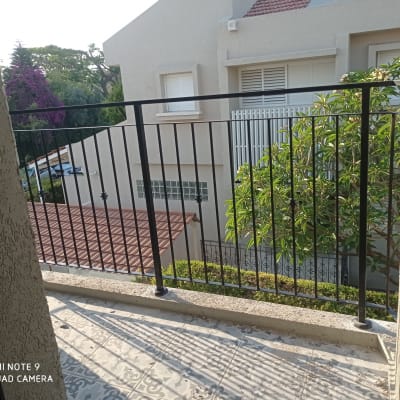 מעקה מתכת שחור במרפסת עם רצפת אריחים