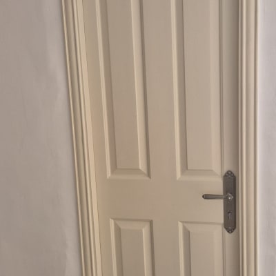 דלת עץ צבועה בצבע בהיר עם ידית מתכת