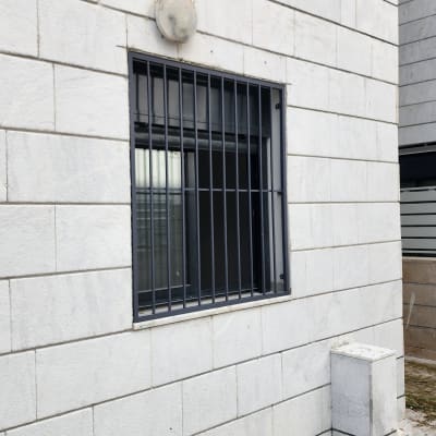 חלון עם סורגים על קיר לבנים חיצוני