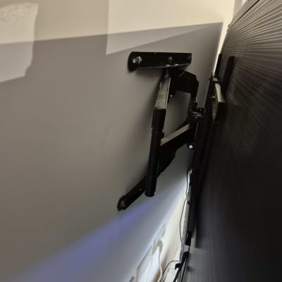 זרוע טלוויזיה מותקנת על קיר עם חיבורים חשמליים