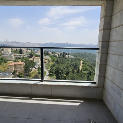 נוף עירוני ממרפסת עם קירות אבן ורצפת אריחים