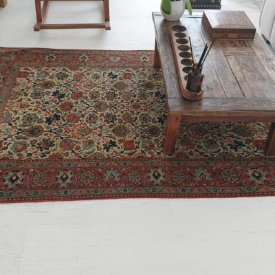 שטיח צבעוני על רצפה לבנה ליד שולחן עץ קטן