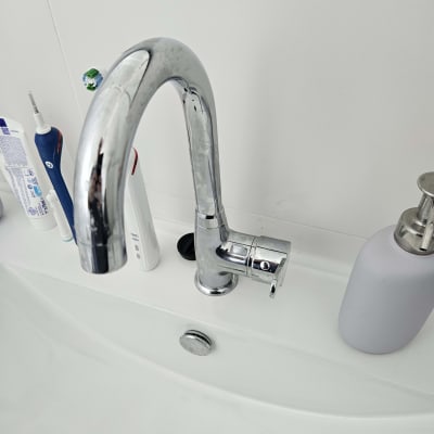 ברז כיור עם מוצרים לידו בחדר אמבטיה