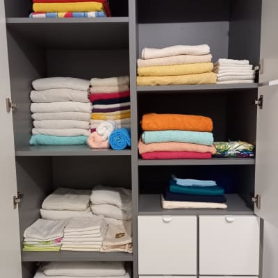 ארון עם מגבות צבעוניות ומדפים מסודרים