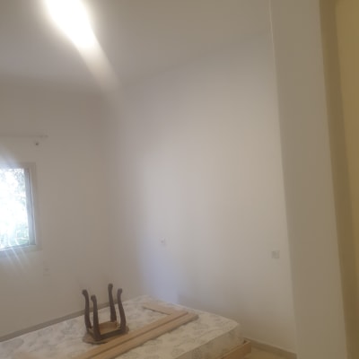 קיר לבן צבוע בחדר עם מיטה