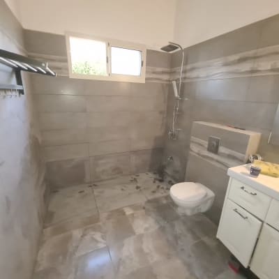 חדר אמבטיה בשיפוץ עם אריחים חדשים ומקלחת מותקנת