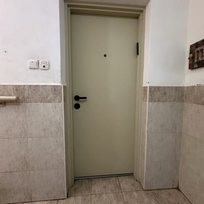 דלת בצבע בהיר עם קירות אריחים מסביב
