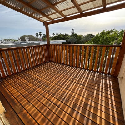 מרפסת עץ עם גג שקוף וצללים על הרצפה