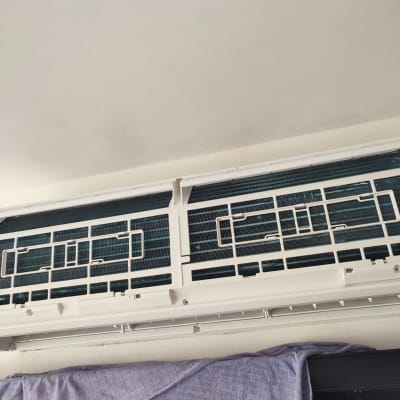 מזגן עם גריל פתוח ומגבת תלויה מתחתיו