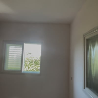 קיר צבוע עם חלון קטן בחדר ריק