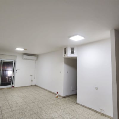 חדר ריק עם רצפת אריחים ומזגן על הקיר