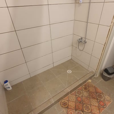 שיפוץ מקלחת עם אריחים חדשים ומדף מתכת