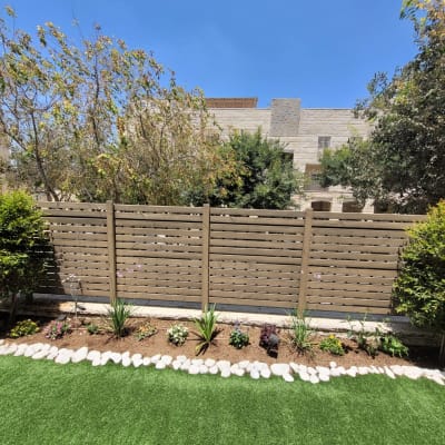 ערוגת פרחים עם אבנים ודשא ירוק