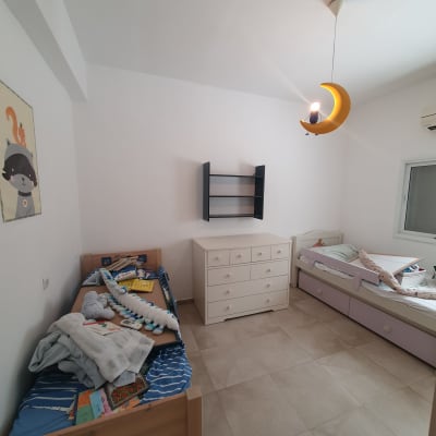 חדר ילדים עם מיטות, שידה ומנורת ירח