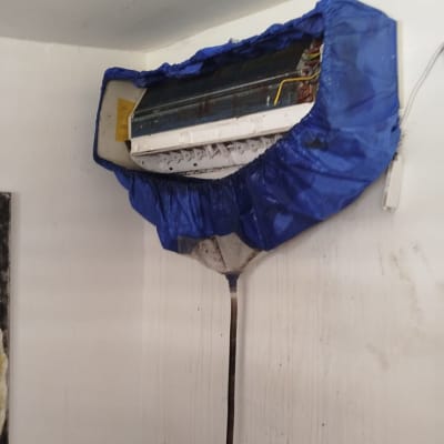 מזגן מכוסה בכיסוי כחול על קיר לבן
