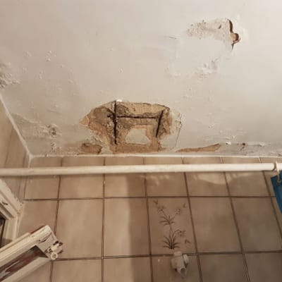 תקרה מתקלפת עם סימני רטיבות ותיקונים