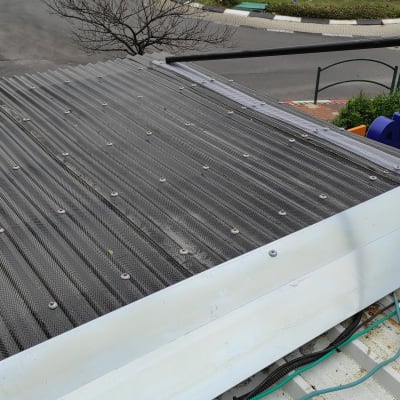 גג מתכת עם ברגים ומעקה שחור