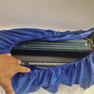 מזגן מכוסה בכיסוי כחול עם יד אדם