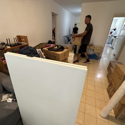 אנשים מעבירים קופסאות בדירה, חלק מתהליך מעבר דירה