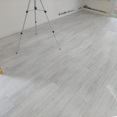 רצפת פרקט עץ בהירה בחדר ריק עם חצובה