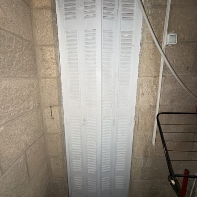 דלת מתקפלת לבנה בקיר אבן