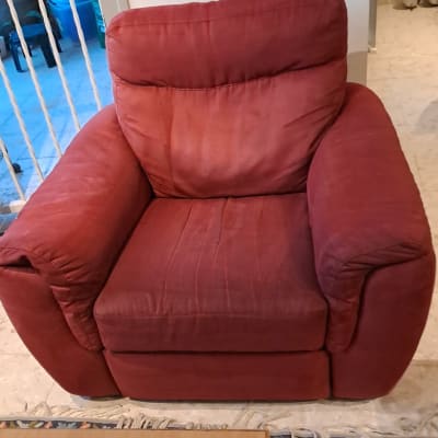 כורסה אדומה בחדר מגורים עם שטיח צבעוני