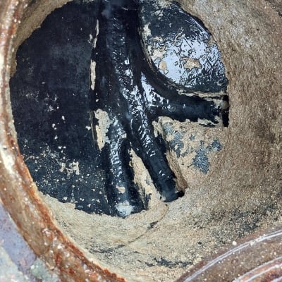 פתח ביוב עם צינור שחור ומים עומדים