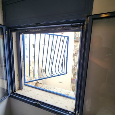 סורגי מתכת כחולים על חלון פתוח