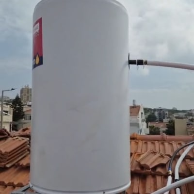דוד שמש לבן מותקן על גבי מעמד מתכת בגג רעפים