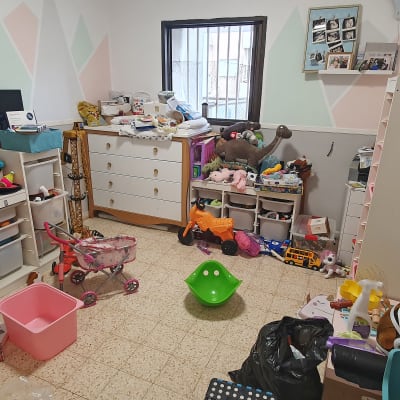 חדר מבולגן עם צעצועים, מדפים וארגזים לאחסון