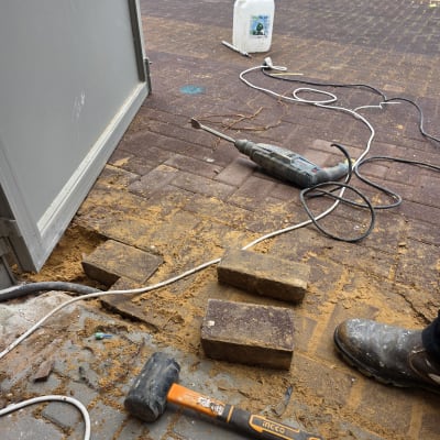 כלים וחומרים להתקנת שער חשמלי על רצפת אבנים