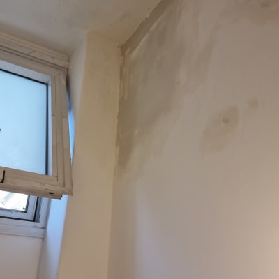 קיר עם תיקוני צבע ליד חלון