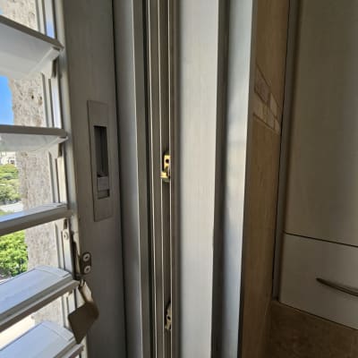 תריסים לבנים ליד חלון עם נוף חיצוני