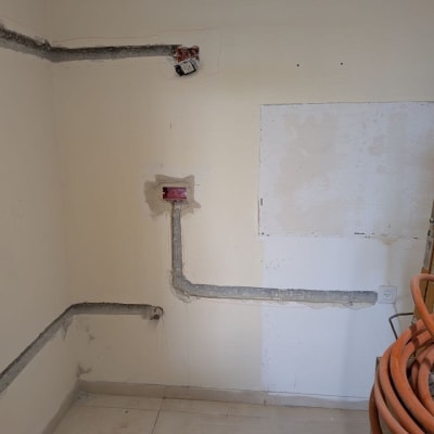 עבודות חשמל בקיר עם צינורות וחוטים