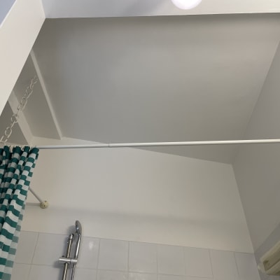 תקרה צבועה עם וילון מקלחת וראש מקלחת