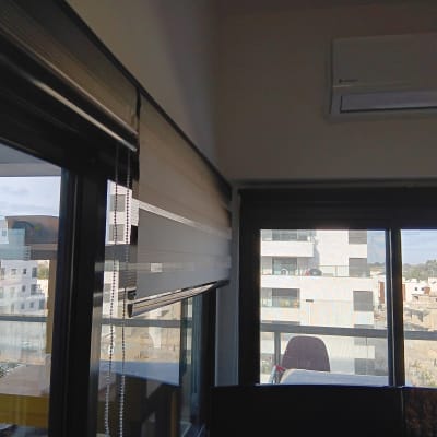 חלון עם תריסים ומזגן על הקיר