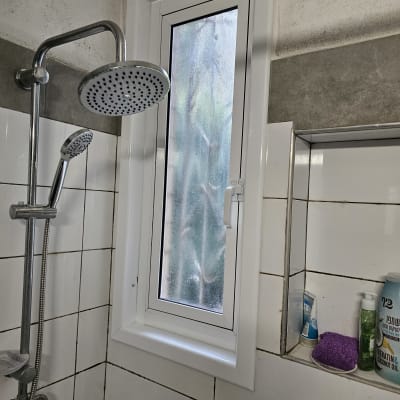 חלון אלומיניום בחדר אמבטיה עם מקלחון