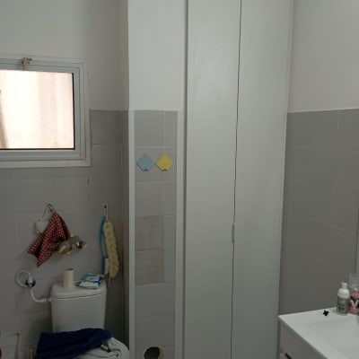 ארון עץ לבן עם דלתות סגורות בחדר אמבטיה