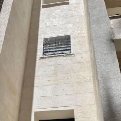 רשת מתכת מותקנת על חלון למניעת כניסת יונים