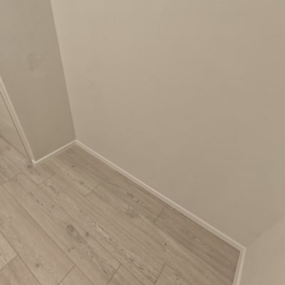 רצפת פרקט עץ בהירה ליד קיר לבן