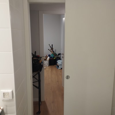 דלת הזזה לבנה פתוחה חלקית במסדרון