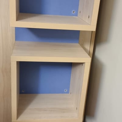 מדף עץ עם ארבעה תאים ריקים על רקע קיר